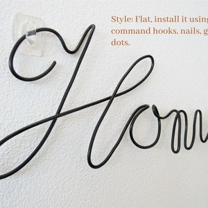 May include: Black metal wire word art that spells out "Home". The word art is flat and can be installed using command hooks, nails, or glue dots.
