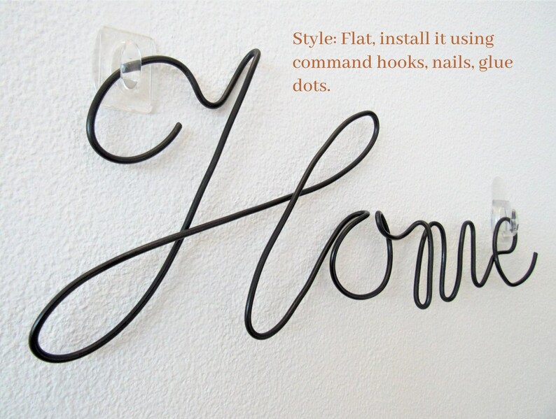 May include: Black metal wire word art that spells out "Home". The word art is flat and can be installed using command hooks, nails, or glue dots.