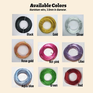 Op de afbeelding: Een selectie van 10 kleuren aluminiumdraad, elke kleur wordt getoond als een spoel draad. De kleuren zijn zwart, goud, zilver, ros&eacute; goud, roze, lila, aquablauw, groen en rood. De draad heeft een diameter van 3,0 mm.