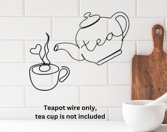 May include: Black wire teapot and teacup sculpture on a white tiled background. The teapot has the word "tea" written on it. The caption below reads "Teapot wire only, tea cup is not included".