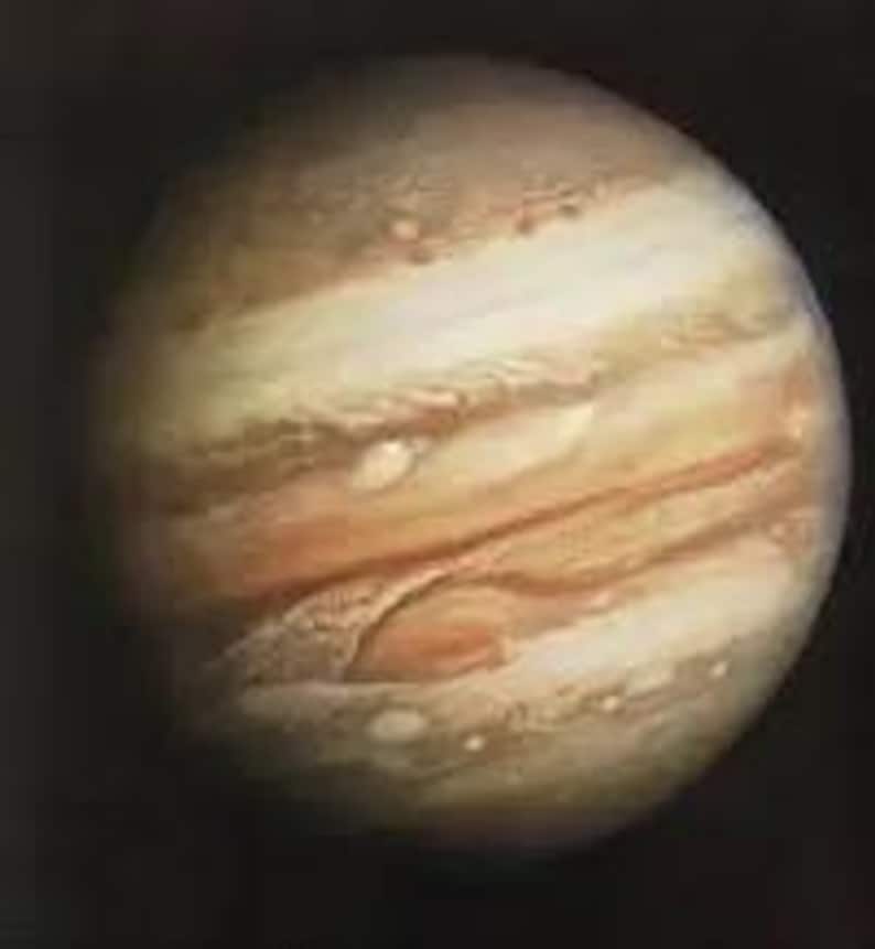 May include: An image of Jupiter, displaying its characteristic banded appearance. The planet's atmosphere is a mix of orange, brown, and white hues, with the Great Red Spot clearly visible. The background is dark, emphasizing the planet's details.