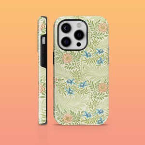 May include: A green, white, and blue floral phone case with a black camera bump. The case features a repeating pattern of leaves, flowers, and birds.