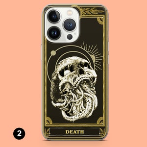 May include: A clear phone case with a black background and gold accents. The case features a graphic of a skull with tentacles, surrounded by a circle and a sun. The text "DEATH" is printed in gold at the bottom of the case.