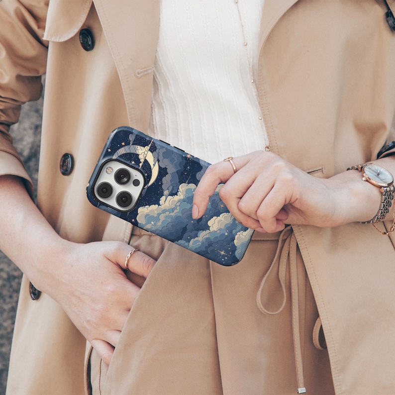 May include: A phone case with a blue and gold design featuring a crescent moon and clouds. The case is made for an iPhone 14 Pro.