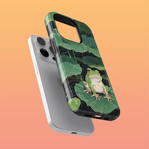 May include: A green frog sits on a large green leaf with smaller green leaves and water droplets in the background. The frog is on a phone case with a black border.