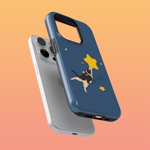 Puede incluir: Una funda de teléfono azul con un gato negro que alcanza una estrella amarilla. La funda tiene un diseño de noche estrellada y es compatible con un iPhone.