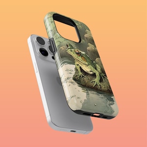 May include: A white iPhone case with a green frog illustration on the back. The frog is sitting on a rock in a pond with water droplets. The case has a clear plastic back and a black frame.