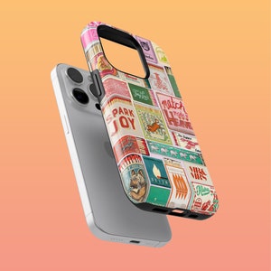 May include: A colorful phone case with a collage of matchboxes featuring various designs and text, including "Spark Joy" and "Match Made in Heaven".