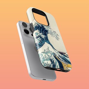 May include: A white iPhone case featuring a colourful image of a large wave crashing against a mountain. The case is made from durable plastic and has a sleek design.