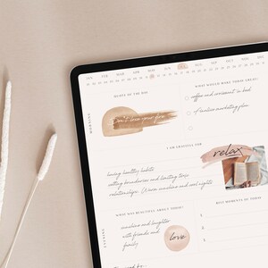 May include: A digital planner on a tablet with a calendar, quote of the day, and sections for morning, evening, and gratitude. The quote is "Don't lose your fire".