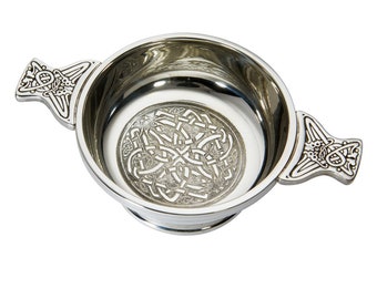 May include: A silver Celtic knot design pewter  quaich, a traditional Scottish drinking vessel with two handles.