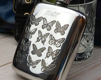 May include: A silver hip flask engraved with a design of butterflies and the initials "G.A.H."