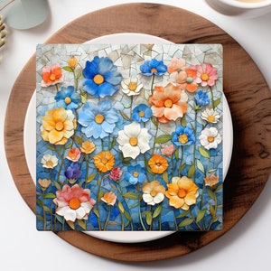 May include: A white ceramic plate with a blue and white floral mosaic design. The plate features a variety of flowers, including blue, pink, and yellow flowers. The plate is surrounded by a wooden coaster.