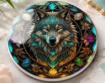 May include: A circular decorative coaster featuring a detailed illustration of a wolf head centred within a stained glass style pattern. The design incorporates vibrant shades of teal, gold, and deep blue, accented by small floral motifs and geometric lines.