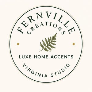A circular logo with a green fern leaf in the center, surrounded by "FERNVILLE CREATIONS" and "LUXE HOME ACCENTS VIRGINIA STUDIO" on a light background.