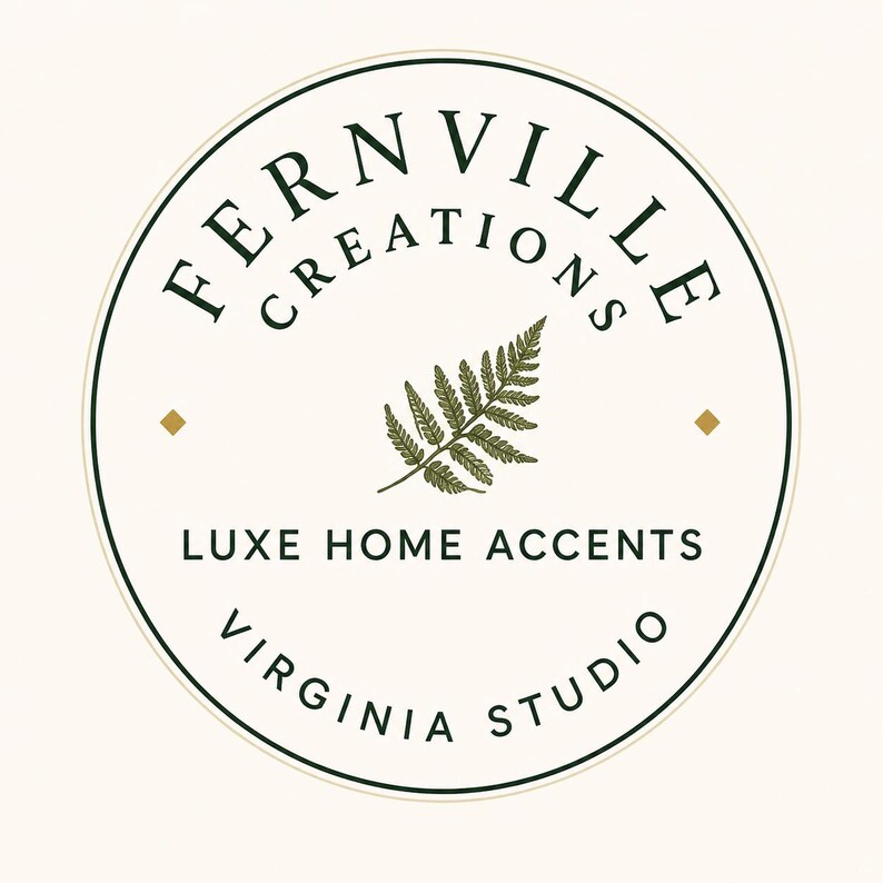May include: Circular logo with the text "FERNVILLE CREATIONS" in a dark green font, with "LUXE HOME ACCENTS" and "VIRGINIA STUDIO" below. A green fern leaf is in the center. The background is off-white with two small gold squares.