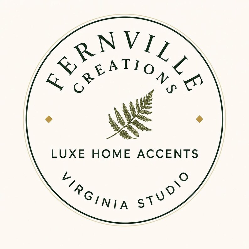 A cream-colored square with a circular logo in the center, featuring the words "FERNVILLE CREATIONS" and "LUXE HOME ACCENTS VIRGINIA STUDIO" in black text, with a green fern illustration.