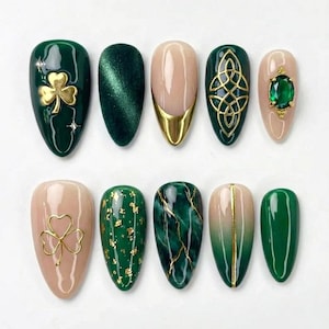Puede incluir: Un conjunto de diez uñas artificiales con varios diseños. Las uñas presentan tonos verdes, nude y dorados. Algunas uñas tienen adornos de tréboles dorados, nudos celtas y gemas. Otras tienen láminas de oro o una raya dorada.