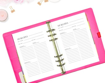 May include: A pink recipe binder with gold rings and a white interior. The binder has the words "My Recipes" printed on the front cover.