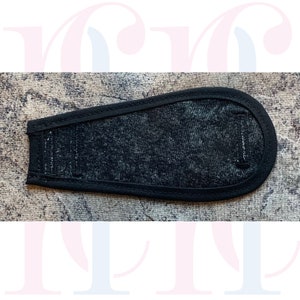 Könnte beinhalten: Schwarzer Stoffgurt mit einem schwarzen Gummiband und einem schwarzen Klettverschluss.