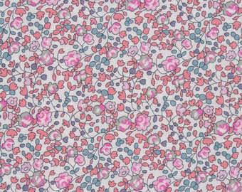 Pode incluir: Um tecido branco com um padrão floral rosa e azul. O padrão apresenta pequenas flores rosas e folhas com detalhes azuis.