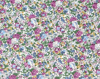 Pode incluir: Um tecido com um padrão floral com uma disposição densa de pequenas flores em tons de roxo, azul, amarelo e branco sobre um fundo branco. As flores são rodeadas por folhas verdes, criando um design vibrante e detalhado.