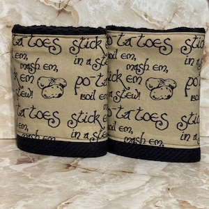 May include: Two beige kitchen towels with black trim and the words "Potatoes" and "Boil em, mash em, stick em in a stew!" in black script. The towels feature a potato graphic.
