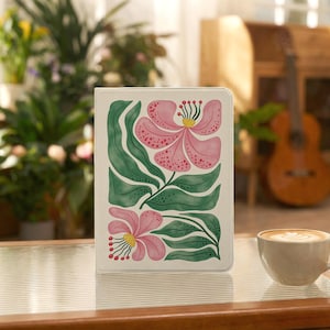 May include: A rectangular tablet case featuring a white background with a painted illustration of two large pink flowers with yellow centres and long green leaves. The design includes small red dots on the petals and green stems.