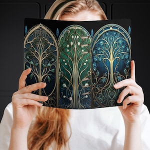 May include: A black binder with three colorful stained glass tree designs. Each tree has a gold frame and is surrounded by a blue and green background.