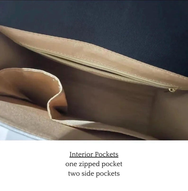 Puede incluir: Vista interior de un bolso con forro beige. El bolso tiene un bolsillo con cremallera y dos bolsillos laterales. Interior Pockets one zipped pocket two side pockets