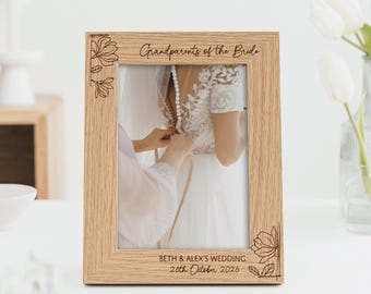 Puede incluir: Un marco de fotos de madera clara con la inscripción "Abuelos de la Novia" y grabados florales. El marco contiene una foto de boda. La fecha de la boda también está grabada.