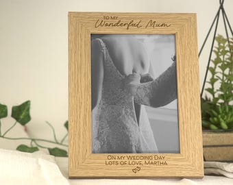 May include: A wooden photo frame with a black and white photo of a person in a dress. The frame has an inscription that reads "To my Wonderful Mum On my Wedding Day Lots of Love, Martha".