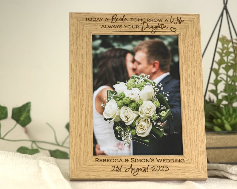 A wooden frame with personalised engraving to give as a wedding favour to the Parents/Father/Mother of the Bride. This design has a contemporary and aesthetic fonts for the name's of who is getting married and the date of the wedding.