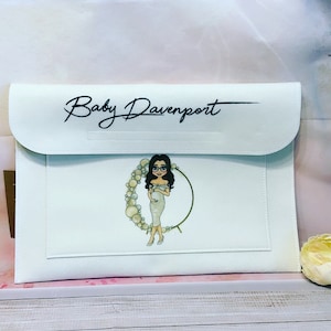 May include: White zippered pouch with a black inscription "Baby Davenport" and a cartoon illustration of a pregnant woman in a white dress with a pearl headband and a gold hoop.