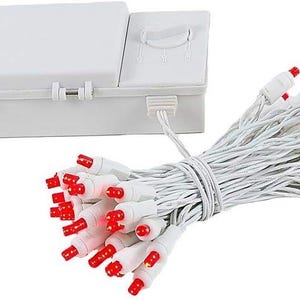 May include: A white battery-operated light set featuring a rectangular control box with a dial and a bundle of white wires connected to multiple small red LED bulbs. The lights are arranged in a compact cluster, showcasing the white casing and red tips.