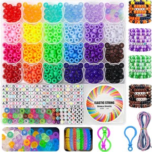 May include: A craft kit featuring a clear plastic organizer filled with assorted colorful pony beads in bear-shaped compartments, square alphabet letter beads, heart beads, smiley face beads, a spool of elastic string, and colorful cord strands.