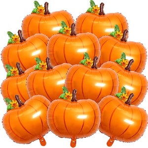 May include: A collection of eleven orange pumpkin-shaped foil balloons. Each balloon features a metallic orange finish with vertical ridges, a brown stem at the top, and a small green leaf accent with a yellow flower detail attached to the stem.