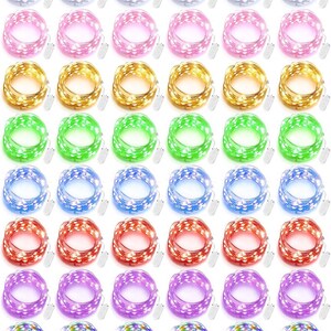 May include: A collection of forty-eight coiled LED fairy light strands arranged in an eight-by-six grid. Each strand features a small white battery pack and is available in various colors including white, pink, gold, green, blue, red, purple, and multicolor.