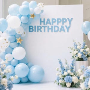 May include: A birthday party decoration featuring a white backdrop with the words "HAPPY BIRTHDAY" in blue. A balloon arch of blue, white, and gold star balloons frames the left side. Floral arrangements with blue and white flowers are at the base.