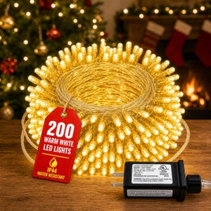 May include: A coil of 200 warm white LED lights with a red rectangular tag that reads 200 WARM WHITE LED LIGHTS and IP44 WATER RESISTANT. A black power adapter plug is attached, featuring a label with technical specifications and UL listing.