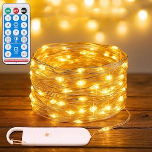 May include: A coil of warm white LED fairy lights on a thin copper wire, accompanied by a white battery pack with a hanging hook and a remote control featuring buttons labeled ON, OFF, RESET, numbers 1 through 8, mode, dim, and timer settings.