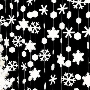 May include: White paper snowflakes and geometric shapes hang from strings against a black background. The decorations vary in size and shape, creating a festive, wintery display. Ideal for holiday decor.