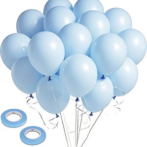 May include: A cluster of light blue balloons tied together with silver ribbons. Two rolls of blue double-sided tape are in the foreground. The balloons are a pastel color, suitable for a party or celebration.