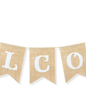 May include: A banner with the word "WELCOME" spelled out in white letters on individual burlap flags. The flags are strung together with a thin, white string, creating a decorative welcome sign.