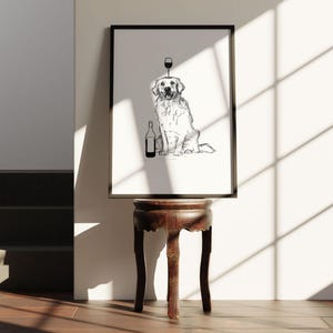 Puede incluir: Dibujo en blanco y negro de un golden retriever sentado con una copa de vino en la cabeza y una botella de vino a su lado. El dibujo est&aacute; enmarcado y colgado en una pared.