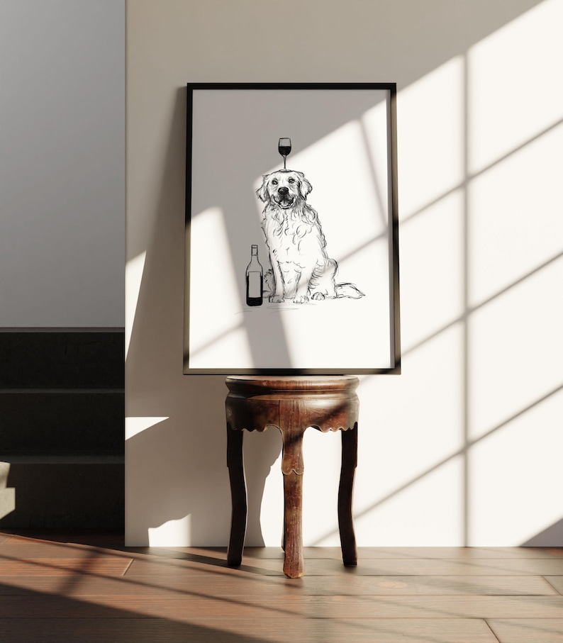 Puede incluir: Dibujo en blanco y negro de un golden retriever sentado con una copa de vino en la cabeza y una botella de vino a su lado. El dibujo est&aacute; enmarcado y colgado en una pared.