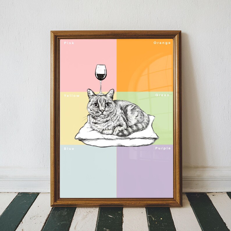 May include: A framed art print featuring a detailed black and white illustration of a cat resting on a pillow, with a wine glass above its head. The background is divided into pink, orange, yellow, green, blue, and purple sections, with corresponding color labels.