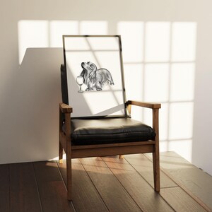 May include: A black and white pencil drawing of a dachshund dog holding a wine glass. The drawing is framed and sitting on a wooden chair with a black leather seat.