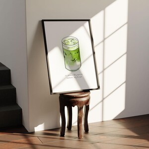 May include: A framed watercolour illustration of a green iced matcha drink in a glass with the text "So somebody gonna make me my green matcha" underneath.
