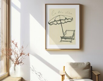 Puede incluir: Una impresión enmarcada con un fondo beige que presenta una ilustración en blanco y negro de una silla de playa y una sombrilla con el texto "La dolce vita" en cursiva.